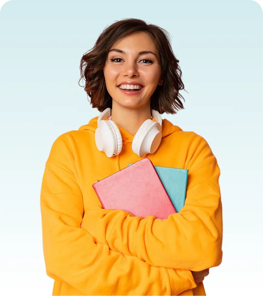 A smiling young woman in a bright yellow hoodie stands against a light blue background, holding two notebooks and wearing white over-ear headphones around her neck.