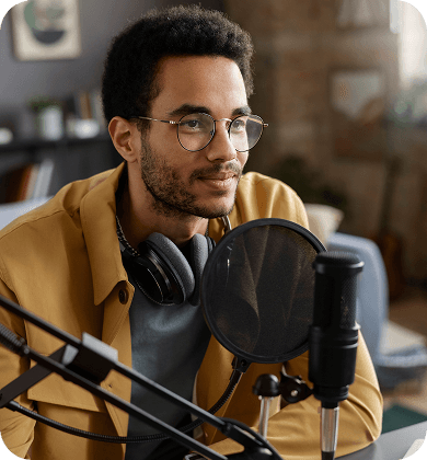 Man with glasses wearing headphones at a microphone setup, illustrating AI-powered audio recording and transcription.