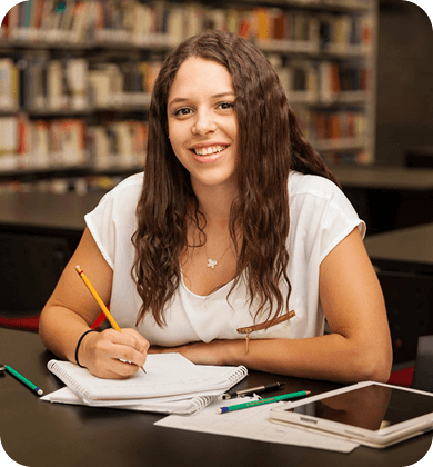 Student studying in a library, writing in a notebook with a tablet beside her, illustrating AI-enhanced note-taking.