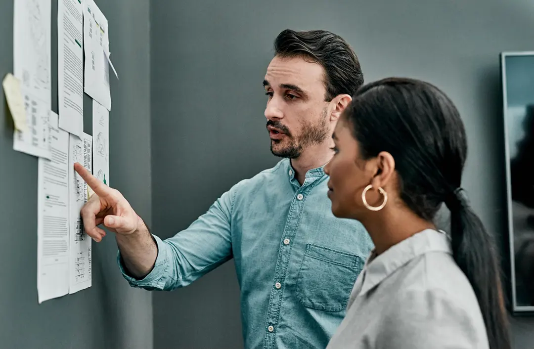 Man & woman sales professionals reviewing the feedback summary of 2,500 client calls registered with Summary AI and gathering objective summary details.