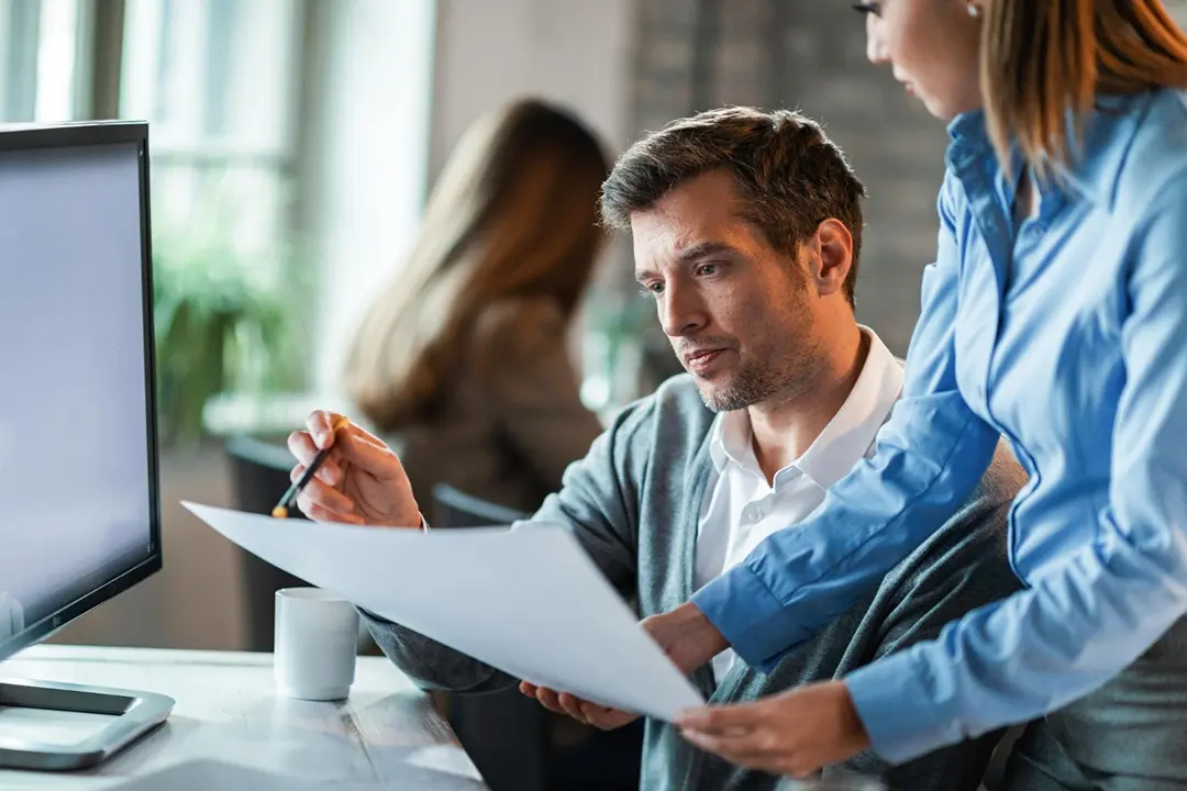 2 sales professionals reviewing an objective summary at the office.