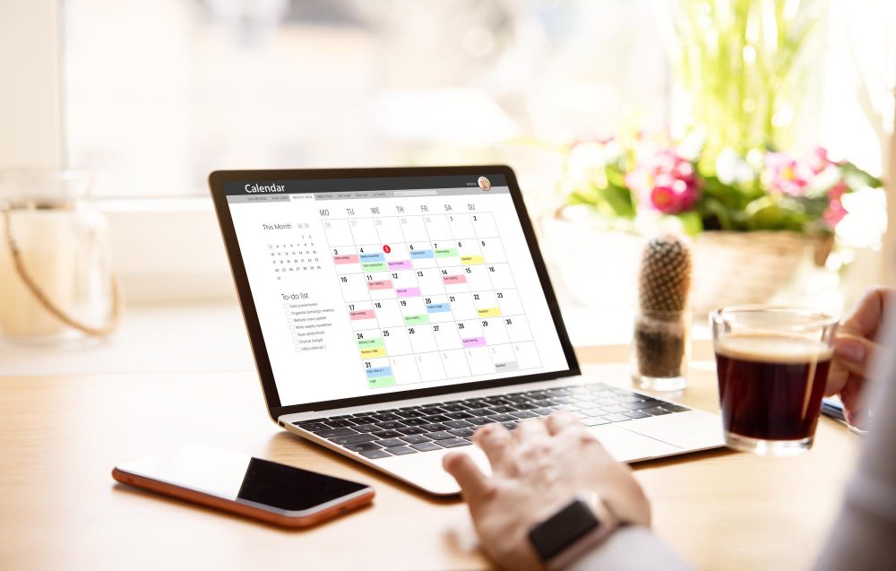Person using calendar sharing app on laptop screen