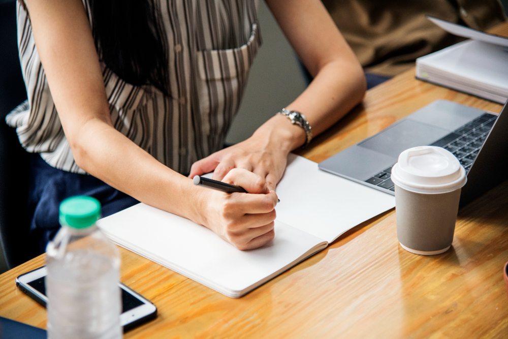 taking notes on paper during a meeting