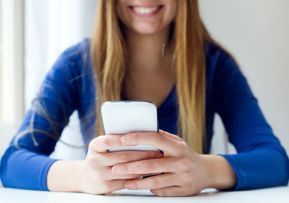 woman looking at visual voicemail and listening to messages