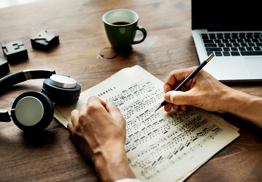 man annotating sheet music at desk