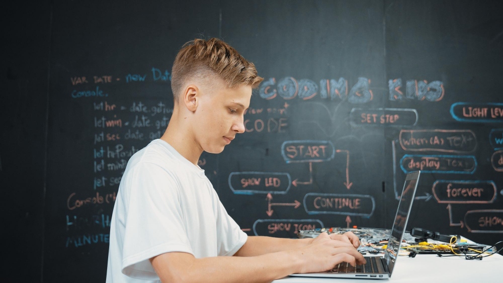 Student coding a Python AI project on a computer 