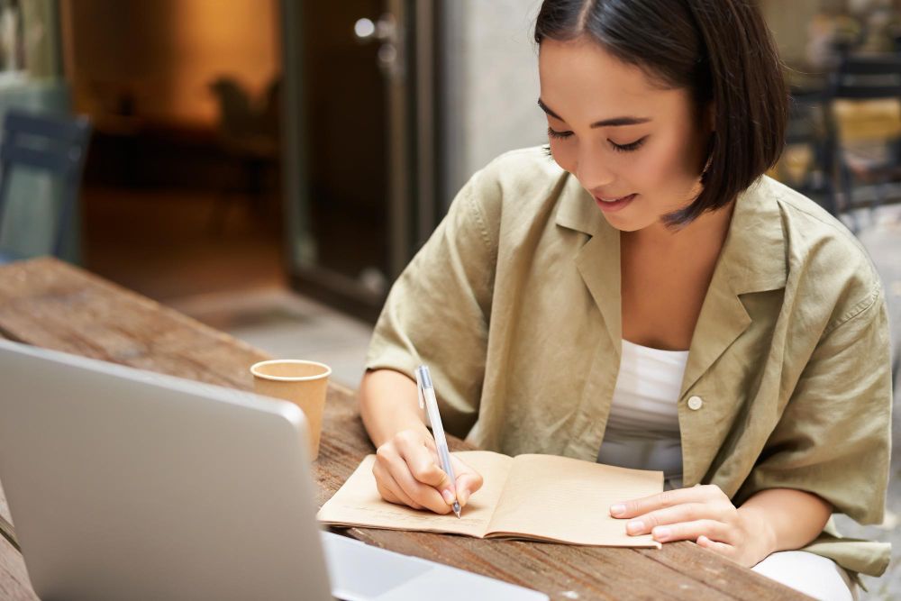 person taking notes on laptop