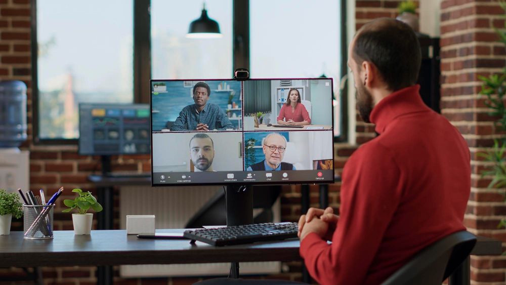 professional attending a video conference on monitor