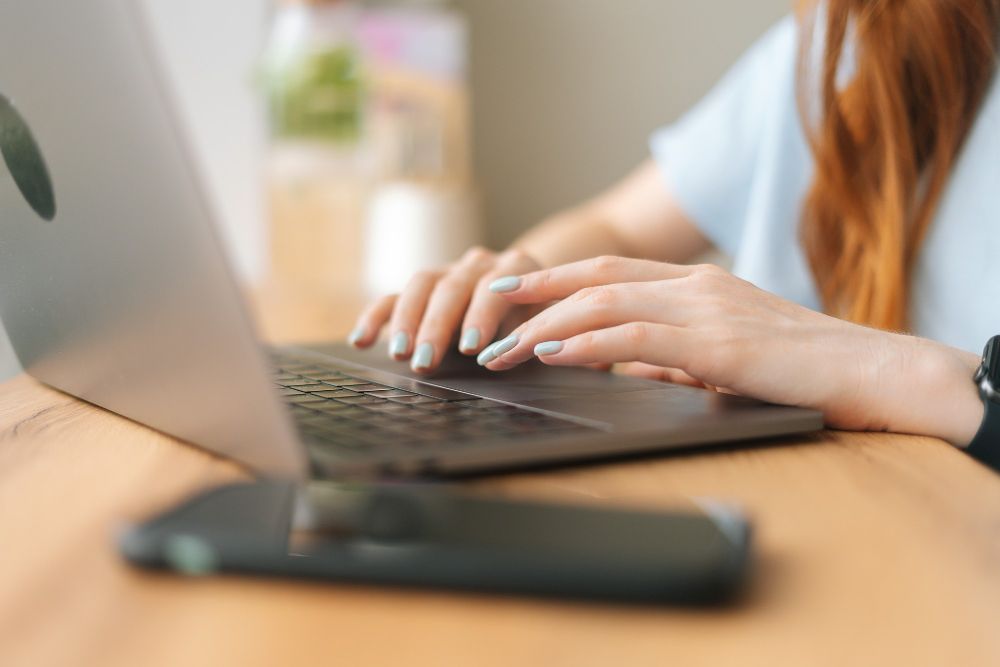 professional typing notes on a laptop