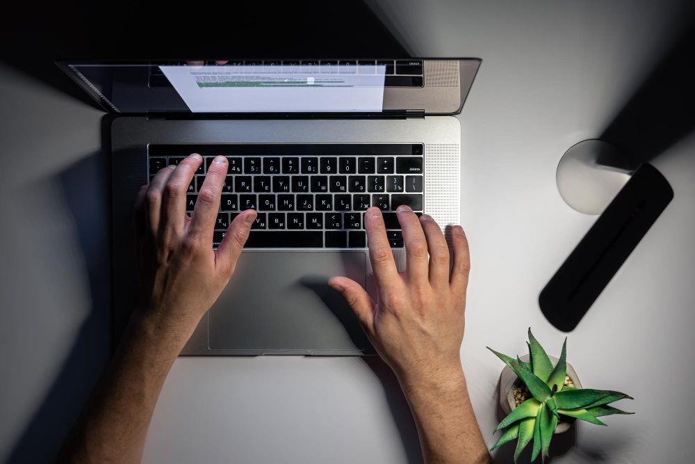 professional typing on laptop at desk