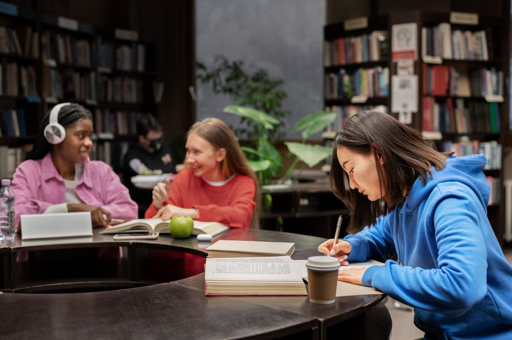 student taking notes while studying in library