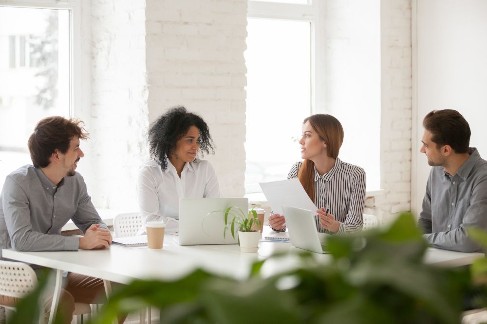 coworkers discussing documents in a team meeting