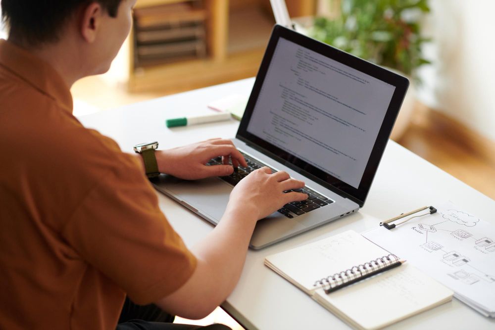 person reviewing text and notes on laptop