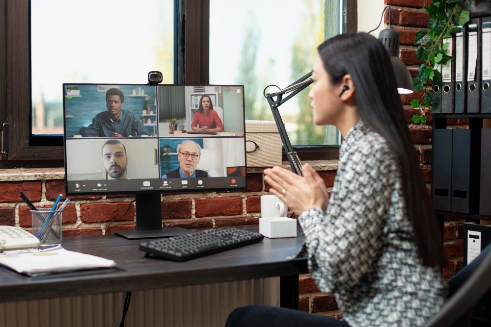 professional joining a video meeting at an office desk